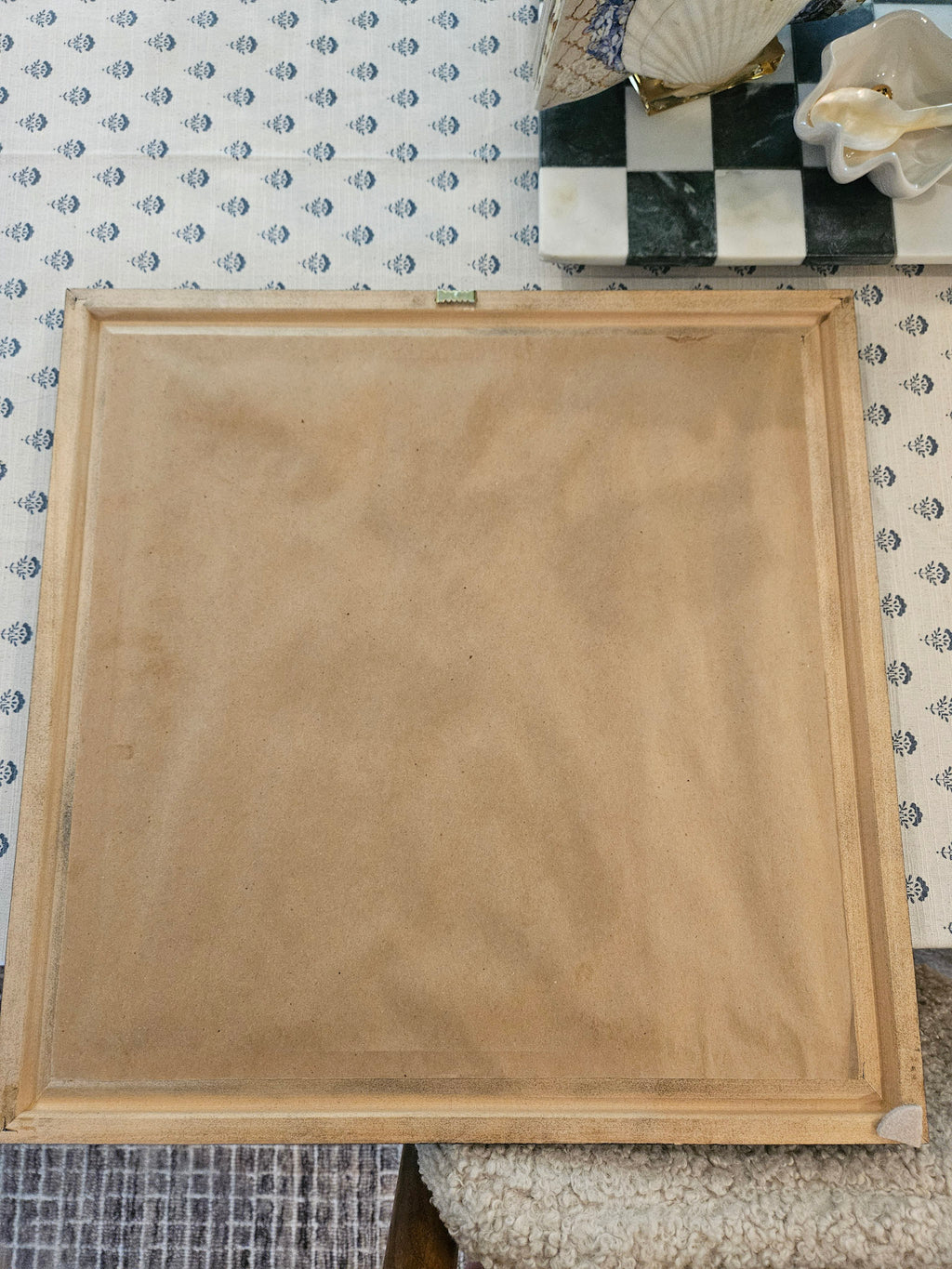 Beige canvas on a checkered floor with decorative elements